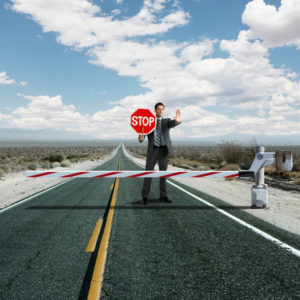 Businessman stopping traffic at roadblock